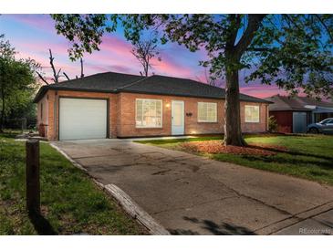 Charming brick home featuring a well-maintained lawn and an attached garage with a concrete driveway at 1269 N Revere St, Aurora, CO 80011