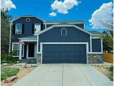 Charming two-story home boasts a spacious two-car garage and meticulous landscaping at 19102 E Hampden Dr, Aurora, CO 80013