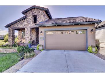 Charming home with a stone facade, landscaped front yard, and a two-car garage at 10553 Fairhurst Way, Highlands Ranch, CO 80126