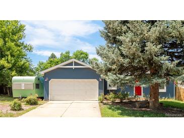 Charming blue home with a two-car garage, mature trees, and a red front door at 12175 Birch St, Thornton, CO 80241