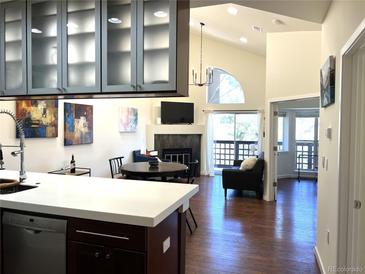 Cozy living room featuring a fireplace, large window, and open floor plan for easy entertaining at 1000 E 1St Ave # 405, Denver, CO 80218
