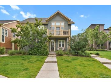Inviting two-story home with a well-manicured lawn and charming balcony at 8260 E 24Th Dr, Denver, CO 80238