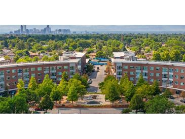 Panoramic aerial view of Central Park neighborhood with buildings, lush trees, and the Denver skyline in the distance at 7700 E 29 Ave # 304, Denver, CO 80238