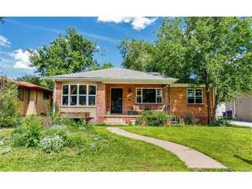 Charming brick home featuring a well-manicured lawn, front porch, and beautiful landscaping at 2240 S Clermont St, Denver, CO 80222