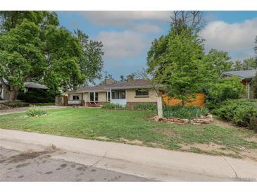 Charming single-story home featuring a well-maintained lawn, mature trees, and brick exterior elements at 5810 S Greenwood St, Littleton, CO 80120