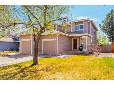 Inviting two-story home featuring a well-maintained lawn, dual garages, and charming curb appeal on a sunny day at 1030 E 78Th Pl, Denver, CO 80229