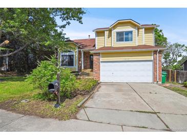 Charming two-story home with a well-manicured lawn, attached garage, and appealing brick accents at 10525 Hobbit Ln, Westminster, CO 80031