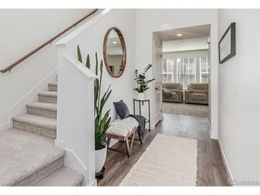 Inviting foyer with staircase, wood floors, and stylish decor, offering a warm welcome at 17825 Gallup St, Broomfield, CO 80023