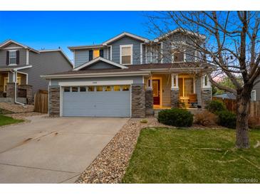 Charming two-story home with stone accents, a spacious driveway, and a manicured lawn at 13818 Krameria St, Thornton, CO 80602