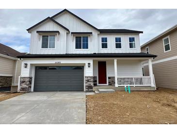 Charming two-story home featuring a gray garage door, a red front door, and a cozy front porch at 25303 E Warren Pl, Aurora, CO 80018