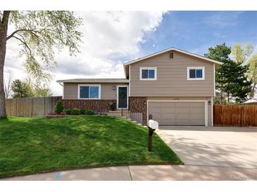 Charming two-story home with a well-manicured lawn and inviting curb appeal at 6141 S Estes St, Littleton, CO 80123