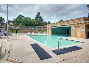 Outdoor pool area with lounge chairs, and well maintained landscaping with attached covered area at 7375 E Quincy Ave # 204, Denver, CO 80237