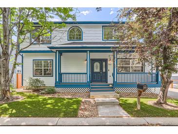 Charming two-story home with a covered front porch and beautiful blue accents on the trim and railings at 511 Noel Ave, Longmont, CO 80501