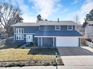 Charming two-story home with a well-manicured lawn, a two-car garage, and a classic, inviting facade at 15592 E Kenyon Ave, Aurora, CO 80013