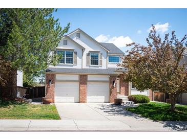 Charming two-story home featuring a three car garage, brick accents, and well-maintained landscaping at 15577 Greenstone Cir, Parker, CO 80134