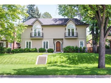 Charming two-story home with manicured lawn and balcony windows at 1160 Monaco Pkwy, Denver, CO 80220