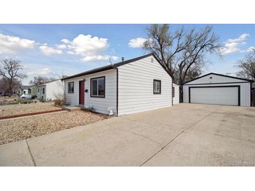 Charming single-story home featuring a long driveway and detached garage at 766 Fulton Ave, Brighton, CO 80601