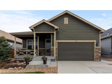 Charming single-Gathering home featuring a covered porch and a two-car garage with stone accents at 549 Tippen Pl, Castle Rock, CO 80104