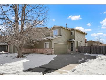 Two-story townhome with attached garage and snowy front yard at 5154 E 126Th Ct, Thornton, CO 80241