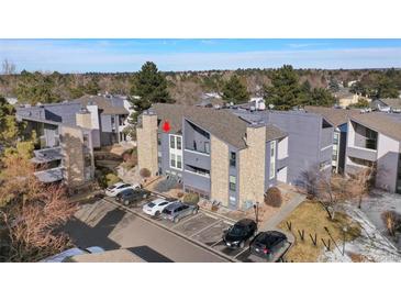 Aerial view of a multi-story building with parking spots and mature trees, complemented by natural stone accents at 9797 E Peakview Ave # C10, Englewood, CO 80111