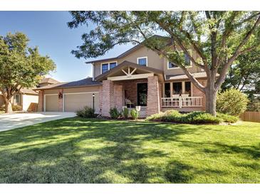 Two-story house with brick accents and a well-maintained lawn at 10697 W Roxbury Ave, Littleton, CO 80127