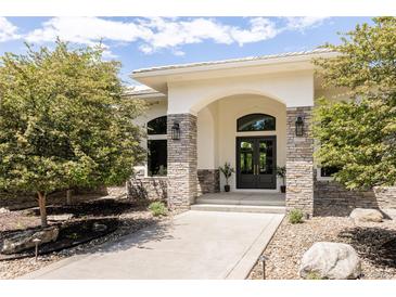 A stately home exterior showcasing a stone facade, archway and double door entry at 8937 Little Raven Trl, Niwot, CO 80503