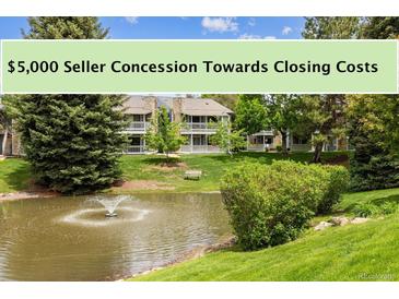 Scenic view of the condo community with a pond and lush landscaping with fountain on sunny day at 8335 Fairmount Dr # 9-201, Denver, CO 80247