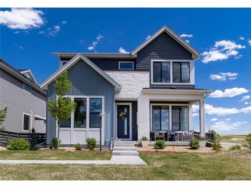 Charming two-story home boasting a mix of siding and stone finishes with beautifully landscaped front yard at 6235 Stable View St, Castle Pines, CO 80108
