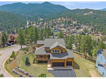 Beautiful exterior of this home featuring professional landscaping, a spacious porch, and a mountain view at 3173 Gold Yarrow Ln, Evergreen, CO 80439