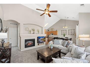 Cozy living room features a fireplace, TV, comfortable seating and high ceilings, perfect for relaxing and entertaining at 22610 E Ontario Dr # 204, Aurora, CO 80016