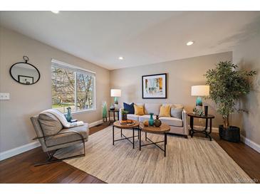Bright living room features hardwood floors, neutral walls, and an inviting seating area at 381 Tynan Dr, Erie, CO 80516