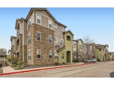 Multi-story apartment building featuring stone accents and manicured landscaping, providing a welcoming curb appeal at 1560 Olympia Cir # 108, Castle Rock, CO 80104