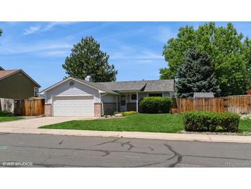 Charming ranch-style home featuring a well-maintained lawn and a two-car attached garage at 7325 S Houstoun Waring Cir, Littleton, CO 80120