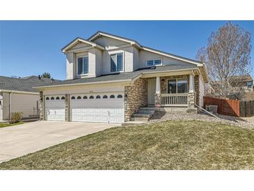Charming two-story home featuring stone accents, a welcoming front porch, and a spacious three-car garage at 12771 Clermont St, Thornton, CO 80241