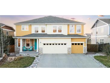 Charming two-story home with yellow siding, stone accents, and a well-maintained front yard at 13753 Jasmine St, Thornton, CO 80602