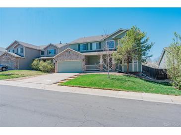 Charming two-story home with a well-manicured lawn and a welcoming front porch at 5149 S Tibet St, Aurora, CO 80015