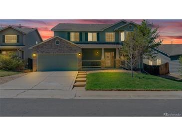 Charming two-story home with a well-manicured lawn and a two car garage during a beautiful twilight at 5149 S Tibet St, Aurora, CO 80015