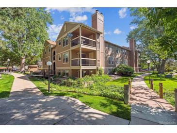 Attractive condo building showcasing balconies, mature trees, and well-manicured landscaping at 10950 W Florida Ave # 314, Lakewood, CO 80232