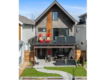 Modern two-story home with a brick facade, balcony, and covered patio featuring an outdoor seating area at 3636 Lipan St, Denver, CO 80211