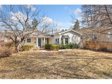 Charming single-story home with a manicured front yard and mature trees, creating a welcoming curb appeal at 1900 S Gilpin St, Denver, CO 80210