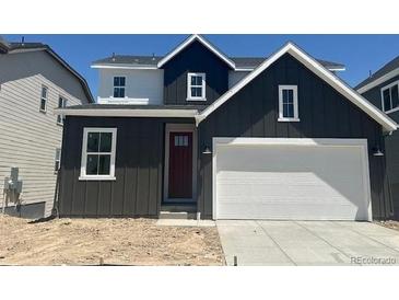 Modern two-story home featuring a gray exterior, a two-car garage, and a red front door at 13350 Blue Amber Ct, Parker, CO 80134