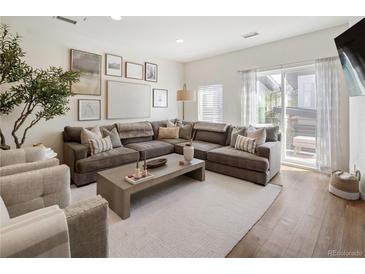 Bright living room features a comfortable sectional sofa, stylish decor, and access to an outdoor patio at 5880 W 39Th Pl, Wheat Ridge, CO 80212