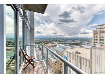 Enjoy city views from this condo's private balcony with glass railings and a seating area at 891 14Th St # 2002, Denver, CO 80202