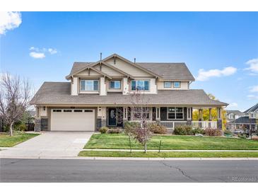 Charming two-story home with a wide front porch, attached two-car garage, and landscaped yard at 6276 S Robertsdale Ct, Aurora, CO 80016