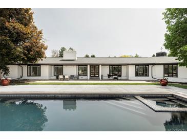Stunning home exterior with a pool, white facade, and a well-manicured lawn, perfect for outdoor living and entertaining at 3801 S Albion St, Englewood, CO 80113