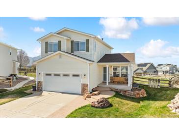 Charming two-story home featuring a spacious two-car garage and a welcoming front porch with stone accents at 9665 Bighorn Way, Littleton, CO 80125