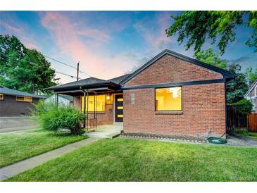 Charming brick home featuring a well-manicured lawn and inviting front porch at sunset at 2731 W 42Nd Ave, Denver, CO 80211