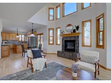 Bright living room with a fireplace, many windows and an open floor plan at 5284 Taft Ct, Arvada, CO 80002