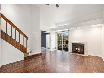 Bright living room features hardwood floors, vaulted ceilings, and a cozy fireplace at 2575 S Syracuse Way # M307, Denver, CO 80231
