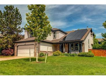 Charming two-story home featuring a manicured lawn, solar panels, and beautiful landscaping at 6647 Lynx Cv, Lone Tree, CO 80124